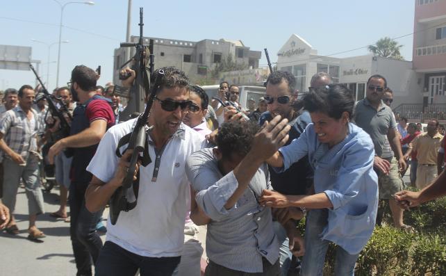 Un suspect (centru) în atacul din staţiunea Sousse este escortat de ofiţeri de poliţie, 26 iunie 2015.