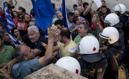 Manifestanţii care susţin rămânerea Greciei în zona euro se încăierează cu poliţia în faţa Parlamentului elen din Atena marţi noaptea, 30 iunie 2015.