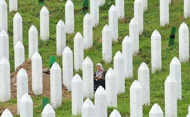 O supravieţuitoare musulmană a masacrului din Srebrenica din 1995 stă într-un cimitir memorial din satul Potocarion, lângă Srebrenica, 10 iulie 2014.