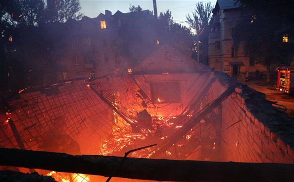 O clădire cuprinsă de flăcări după un schimb de focuri de artilerie între forţele ucrainene şi separatiştii pro-ruşi în oraşul Doneţk, 18 iulie 2015.