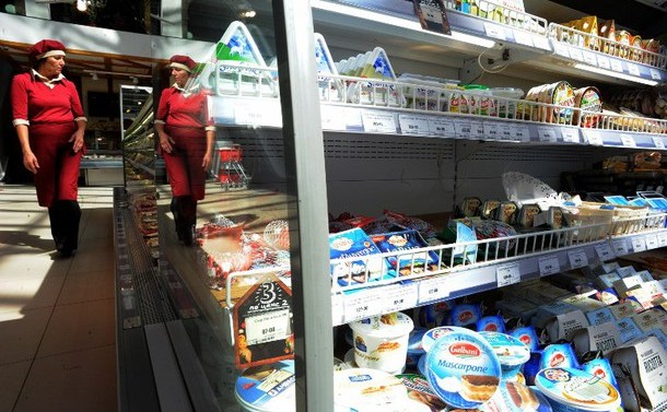 O vânzătoare trece pe lângă o vitrină frigorifică într-un supermarket din Saint Petersburg, 7 august 2014.