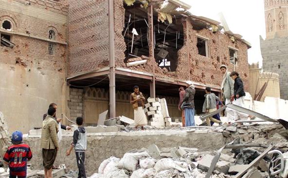 Cetăţeni yemeniţi stau în mijlocul unor clădiri distruse de un atac aeriana saudit în capitala Sana’a, 16 iulie 2015. (Captură Foto)