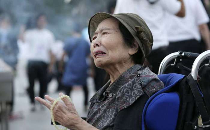 O rezidentă din Hiroshima plânge în timp ce se roagă pentru victimele provocate de bomba atomică aruncată de americani asupra oraşului în 1945.