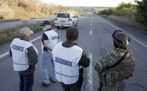 Un soldat ucrainean şi observatori OSCE se află pe un drum în apropiere de Doneţk. (Captură Foto)