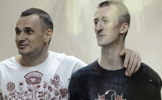 Regizorul ucrainean Oleg Senţov (st) şi activistul Alexander Kolcenko se află în boxa acuzaţilor în timp ce participă la o audiere de tribunal în oraşul rusesc Rostov-pe-Don.