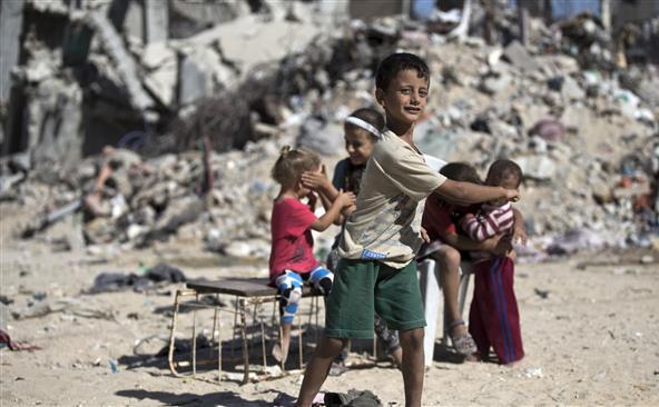 Copii palestinieni se joacă lângă rămăşiţele unor clădiri distruse în Gaza City în timpul atacului desfăşurat de Israel timp de 50 de zile asupra Fâşiei Gaza în vara lui 2014.