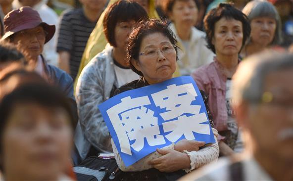 O femeie participă la un protest desfăşurat în Tokyo împotriva noilor legi privind securitatea naţională, 26 august 2015.