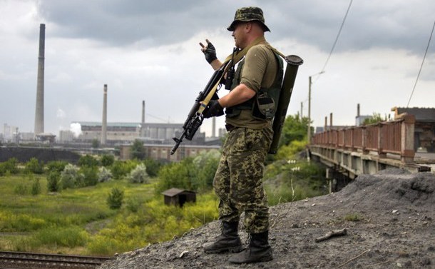 Un soldat ucrainean patrulează în apropiere de o centrală chimică din Avdeevka, regiunea Doneţk, 20 iunie 2015.