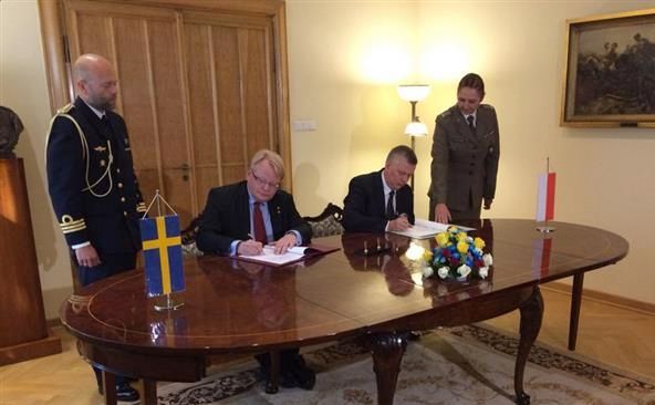 Premierul polonez Tomasz Siemoniak (al doilea din dreapta) şi omologul său suedez Peter Hultqvist semnează în Varşovia un acord pentru consolidarea cooperării militare bilaterale, 14 septembrie 2015.