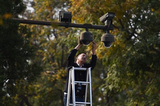 Un lucrător reglează camere de securitate în Piaţa Tiananmen din Beijing pe 30 septembrie 2014 (Greg Baker/AFP/Getty Images)