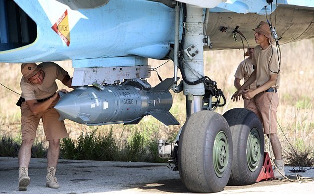 Soldaţi ruşi înarmează un avion de luptă Su-34 cu o bombă ghidată prin satelit, la baza aeriana Hmeimim din Siria.