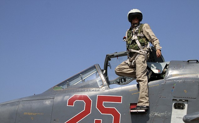Pilot rus pozează lângă cabina unui avion de luptă Su-25M la baza aeriană Hmeimim din Siria.