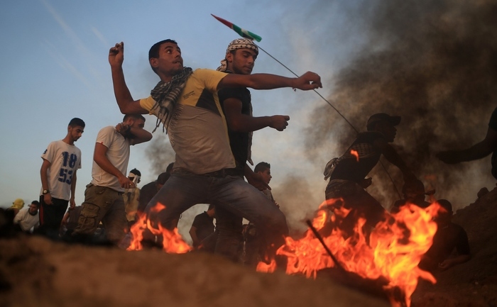 Tineri palestinieni aruncând pietre către armata israeliană, Gaza, 13 octombrie 2015