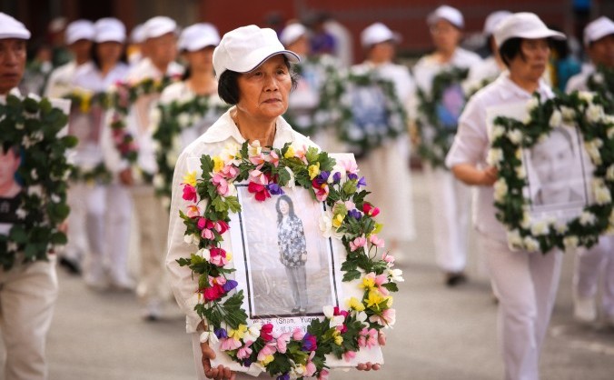 Participanţii la o paradă în Los Angeles afişează fotografii cu practicanţii Falun Gong ucişi în cadrul persecuţiei desfăşurate în China, 15 octombrie 2015.