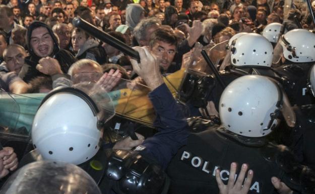 Un poliţist îl loveşte cu un baston pe liderul opoziţiei muntenegrene Nebojsa Medojevic (cu faţa la cameră, în dreapta bastonului) în timpul unui protest al opoziţiei în Podgorica, 17 octombrie 2015.