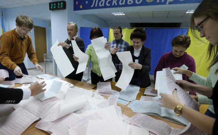 Membrii unei comisii electorale locale numără buletinele de vot la o secţie de votare din Kiev, 25 octombrie 2015.