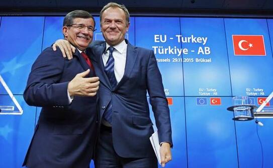 Premierul turc Ahmet Davutoglu (st) şi preşedintele Consiliului European Donald Tusk se felicită după finalizarea summitului UE-Turcia din Bruxelles, 29 noiembrie 2015. (Captură Foto)