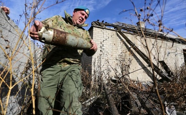 Un separatist pro-rus transportă un proiectil neexplodat în satul Veseloe, în apropiere de Doneţk, 18 octombrie 2015.