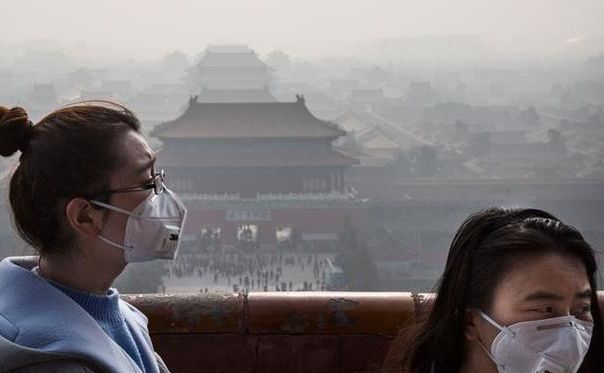 Oamenii poartă măşti de protecţie în Beijing datorită aerului foarte poluat.