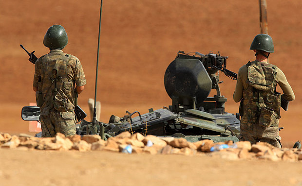Soldaţi turci stau lângă un vehicul blindat staţionat între poziţiile de luptă ale kurzilor sirieni şi ale militanţilor din Statul Islamic. (Captură Foto)