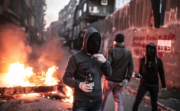 Demonstranţi purtând măşti se pregătesc să arunce coctailuri Molotov în forţele de poliţie care încearcă să disperseze un protest folosind gaze lacrimogene, Istambul. 20 decembrie 2015