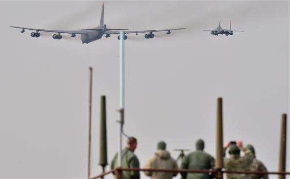 Soldaţi americani privesc un bombardier B-52 (st), care este escortat de un avion de luptă sud-coreean F-15K (dr), în timp ce zboară deasupra bazei aeriene Osan din Pyeongtaek, 10 ianuarie 2016.