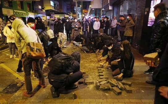 Manifestanţii se înarmează cu cărămizi în timpul protestelor din Hong Kong, 9 februarie 2016. (Captură Foto)