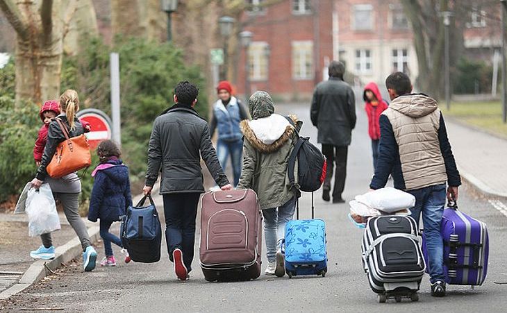 Refugiaţi sosesc la un centru de înregistrare pentru solicitanţi de azil din Berlin.