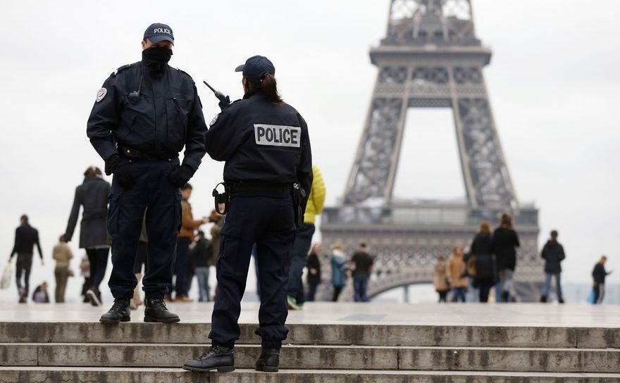 Poliţişti francezi stau de pază în apropiere de Turnul Eiffel din Paris.