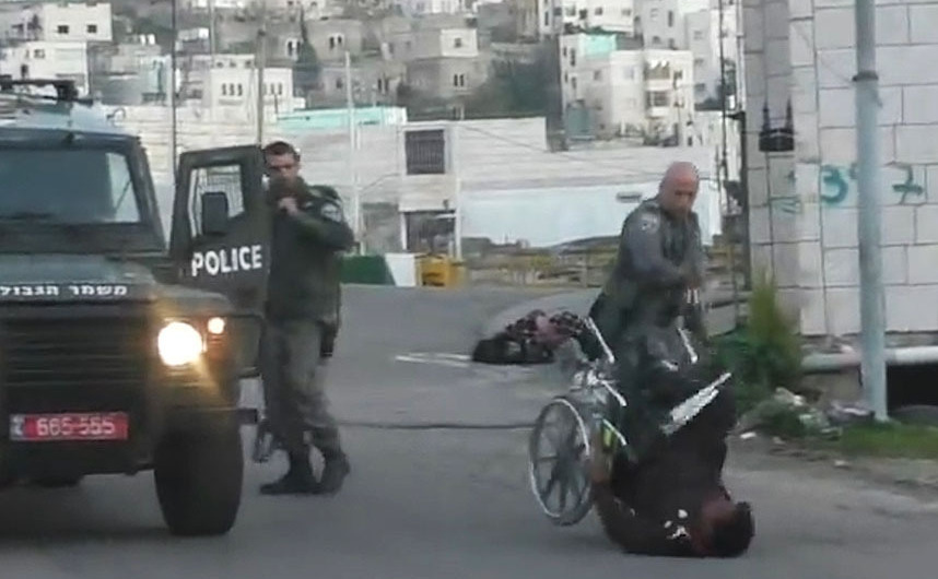 Un soldat israelian răstoarnă din scaunul său cu rotile un palestinian invalid în oraşul Hebron, 14 februarie 2016. (Captură Foto)