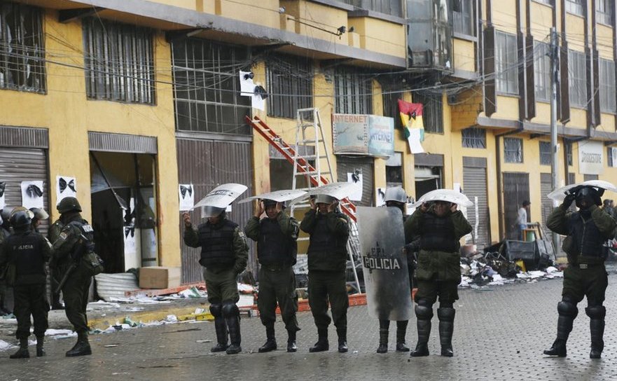 Poliţia păzeşte o clădire municipală ce a fost incendiată de manifestanţi în oraşul bolivian El Alto, 17 februarie 2016.
