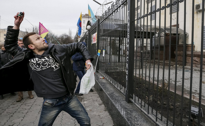 Un manifestant aruncă o sticluţă cu vopsea verde către clădirea ambasadei ruse din Kiev, 6 martie 2016.