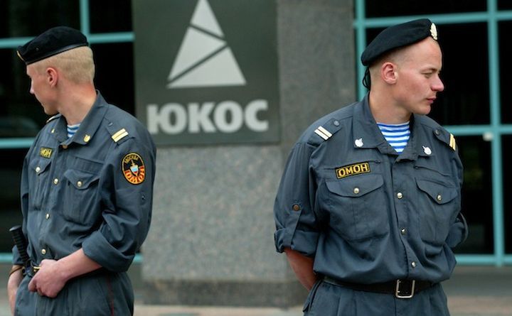 Paznici stau în faţa sediului fostei companii Yukos în Moscova.