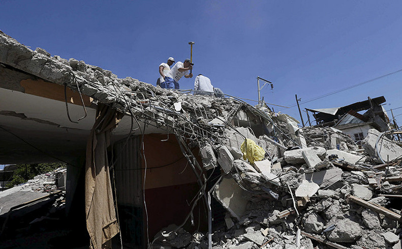 Rezidenţii lucrează la o casă prăbuşită în Pedernales după un cutremur de pământ de a lovit Ecuadorul în 16 aprilie 2016.