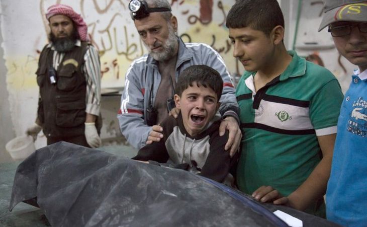 Un băiat sirian plânge lânga trupul unei rudenii ucise într-un atac aerian în oraşul sirian Alep, 27 aprilie 2016. (Karam Al-Masri/AFP/Getty Images)