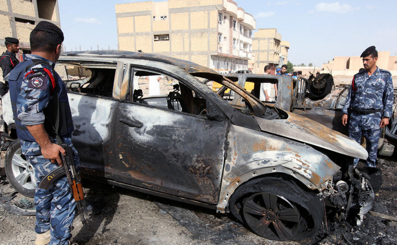 Poliţiştii inspectează locul exploziei unei maşini capcană în Samawa, Irak, 1 mai 2016.