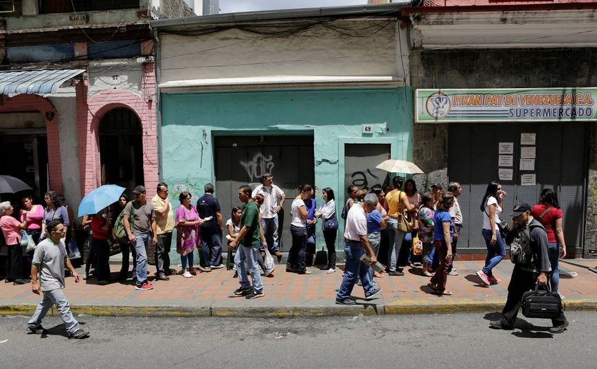 Oamenii stau la coadă în faţa unui supermarket din Caracas, Venezuela, 28 aprilie 2016.