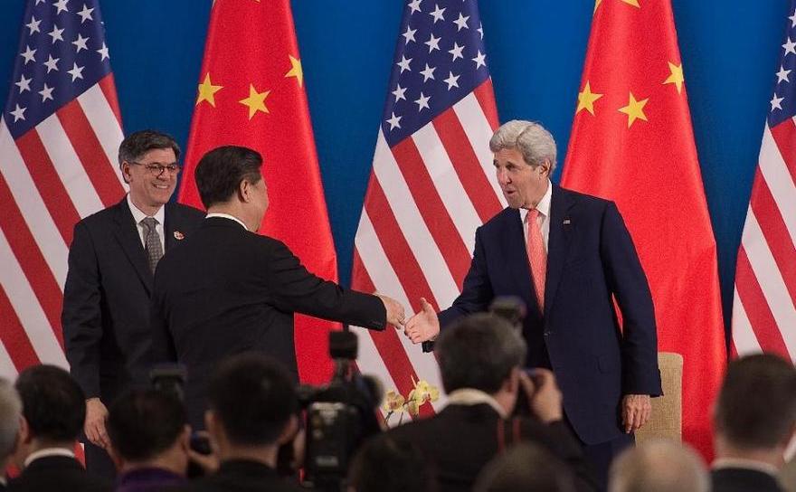 Preşedintele chinez Xi Jinping (cu spatele) îl salută pe secretarul de stat american John Kerry în timpul sesiunii de deschidere a Summitului SUA-China din Beijing, 6 iunie 2016.