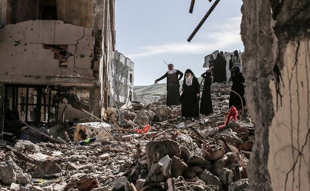 Kurzi mergând printre casele ruinate de bombardamentele armatei turce, în Cizre (dw.com)