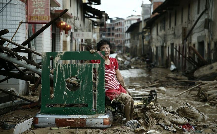 O femeie stă pe o stradă în Minqing, provincia chineză Fujian, după trecerea taifunului Nepartak, 10 iulie 2016.