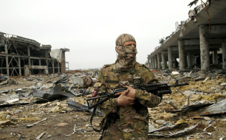 Luptător separtist stă de pază în apropierea unor clădiri distruse pe aeroportul din Doneţk, estul Ucrainei, 1 iunie 2016. (Captură Foto)
