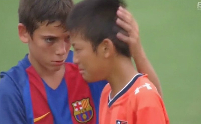 
Un tânăt fotbalist de la F.C. Barcelona consolează un tânăr fotbalist de la Omiya Ardija