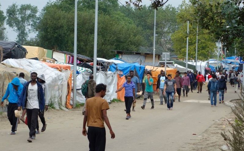 Imigranţi se plimbă în partea nordică a unei taberei pentru refugiaţi (numită Jungla) în oraşul francez Calais, 6 septembrie 2016.