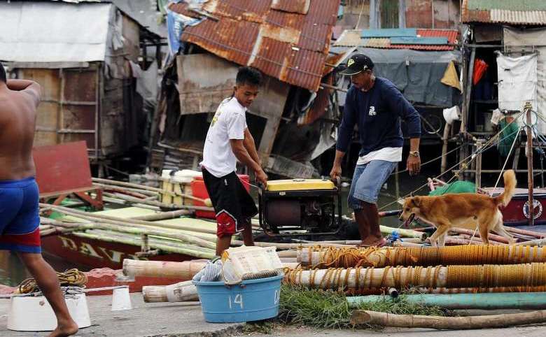 Pescari filipinezi se pregătesc să evacueze oraşul Las Pinas, 15 octombrie 2016.
