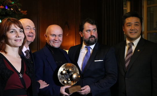 Raul Dudnic, director executiv al televiziunii  ROMEDIA, ţinând în mână scultpura "NOI" oferită ca premiu de d-nul consul Doru Liciu(în mijloc) (Maria Matyiku/ Epoch Times)