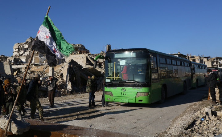 Un convoi cu autobuze şi ambulanţe aşteaptă la un punct de trecere în districtul Amiriyah din oraşul sirian Alep, 15 decembrie 2016, pentru a evacua civilii blocaţi în oraş.