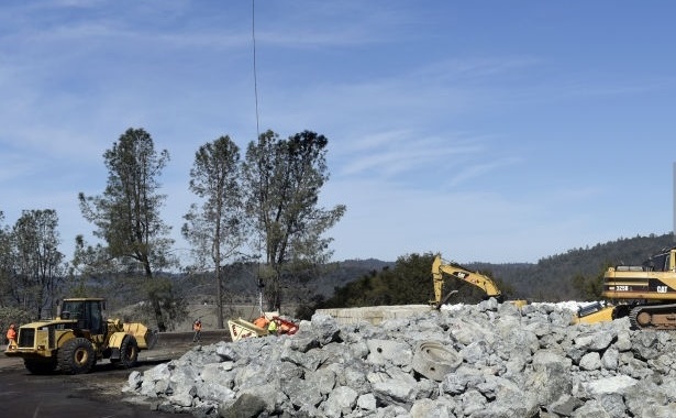 Tone de piatra sunt ridicate in aer cu elicoptere pentru a consolida barajul. (Getty Images)