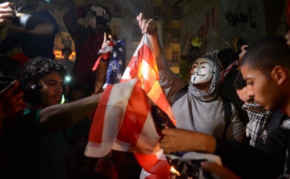 Susţinători ai Frăţiei Musulmane ard steagul american într-un protest împotriva armatei egiptene din Cairo, la 22 ianuarie 2014