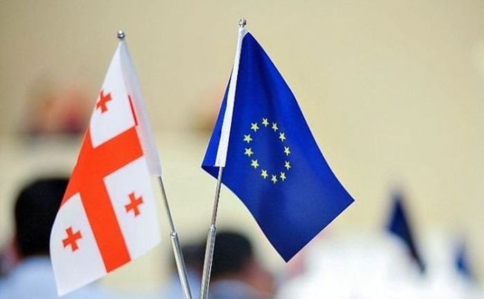 Mini-steag al Uniunii Europene alături de un mini-steag al Georgiei. (Captură Foto)