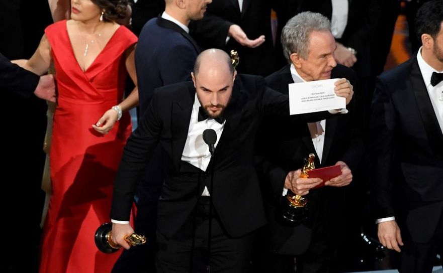 Producătorul filmului La la land,  Jordan Horowitz, arată cartonaşul cu numele filmului câştigător "Moonlight", împreună cu actorul Warren Beatty